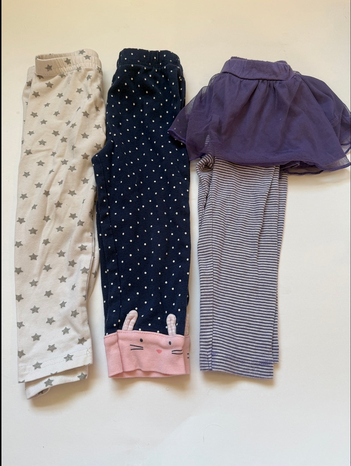 #170 Carters pants bundle (3)—white with silver starts, navy with white polka dots and pink bunnies at ankle and purple and white stripe with tulle skirt girls 3 months