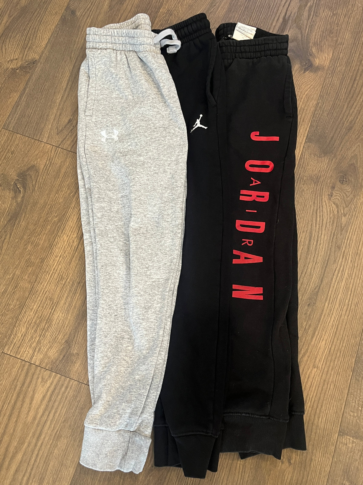 135 YM boys sweatpants 2 pairs of Black Jordan pants and 1 grey under Armour sweat pants, LN, all 3 have pockets (3 pairs total)