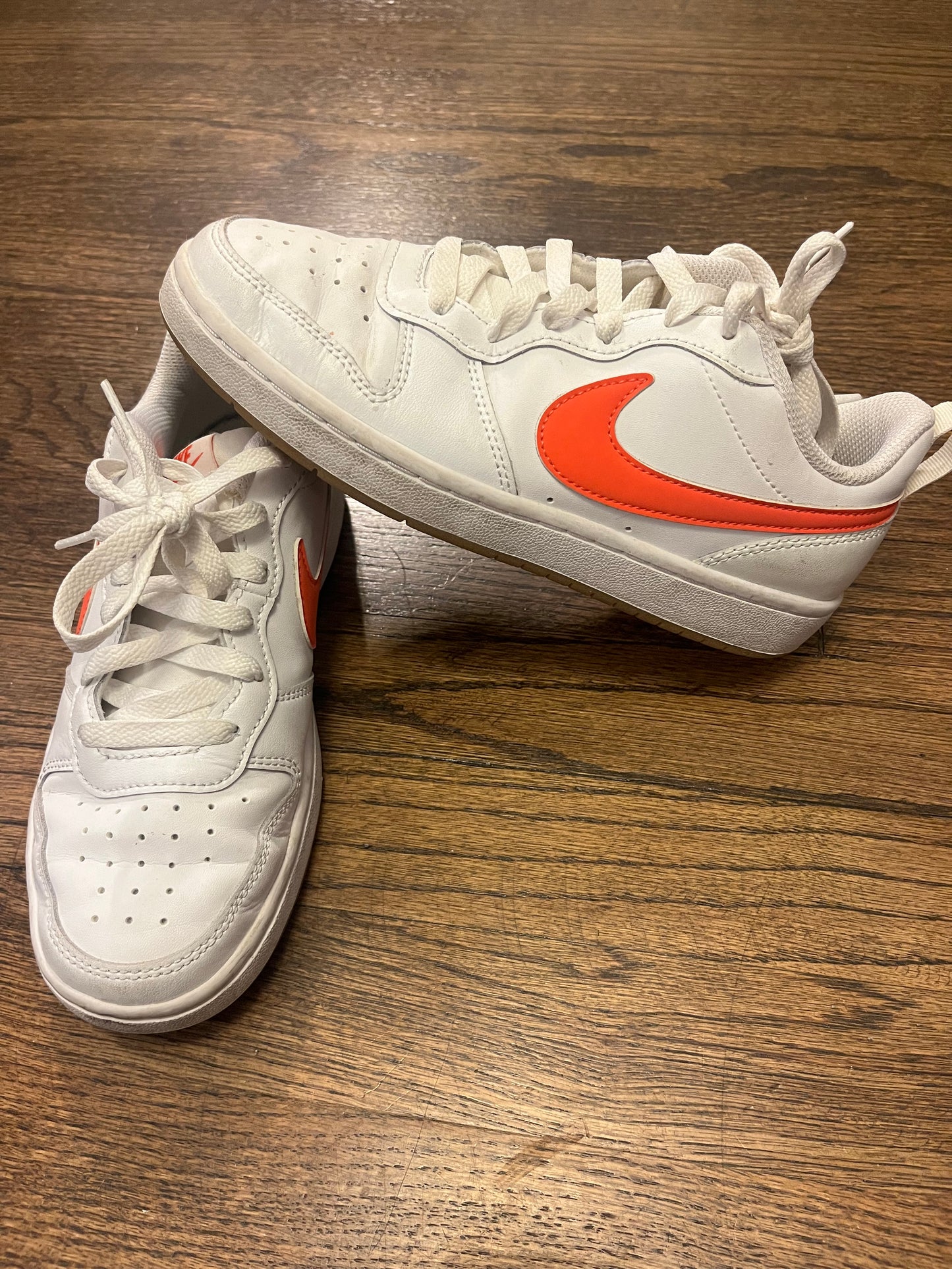 #67 Nikes with orange swish 4Y