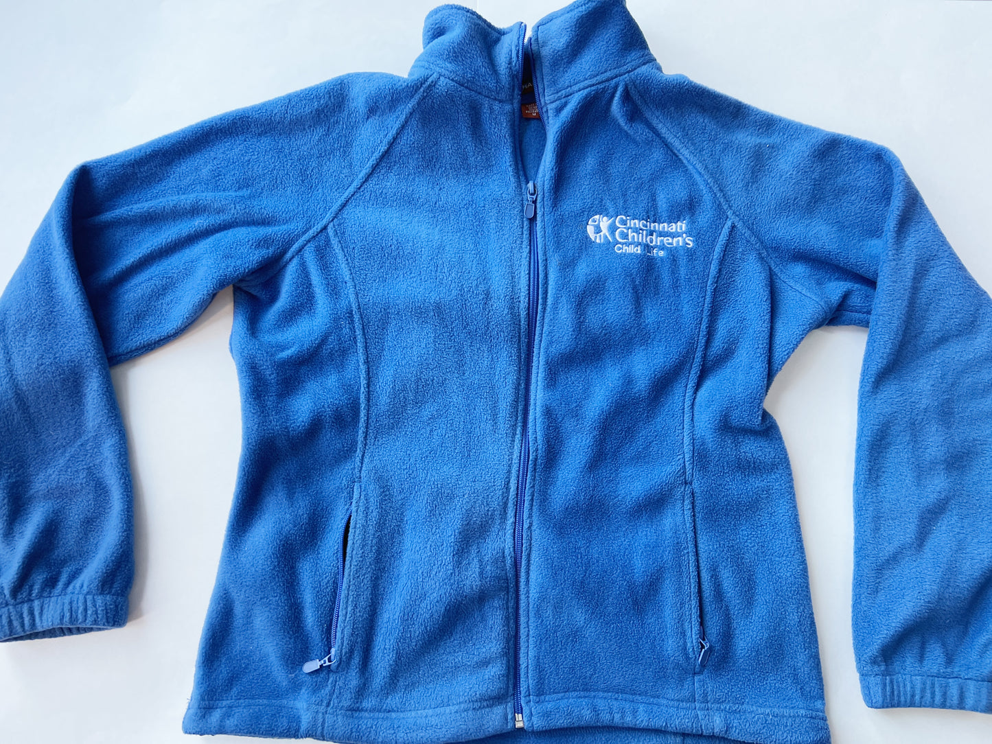 Size M blue Cincinnati Children’s Child Life zip-up (old logo). Zippered pockets and drawsting bottom for adjustable fit. VGUC.